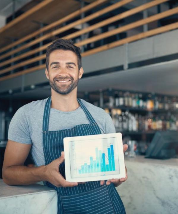 A man with a tab in hand displaying chart with growth pattern