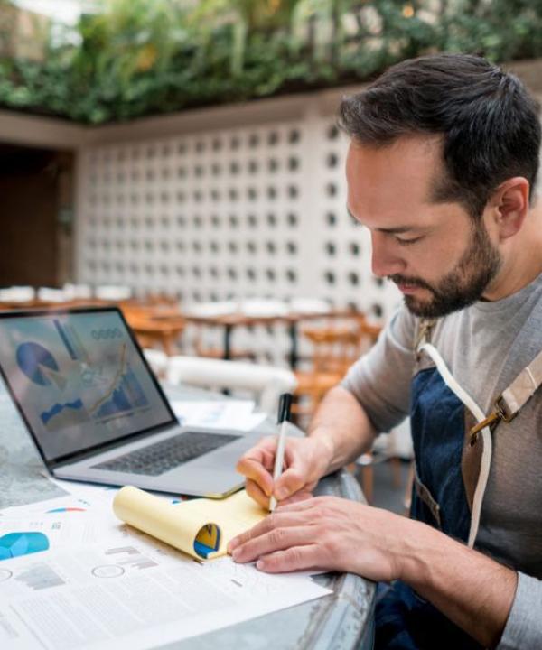 A person fixing the workflows on computer and paper
