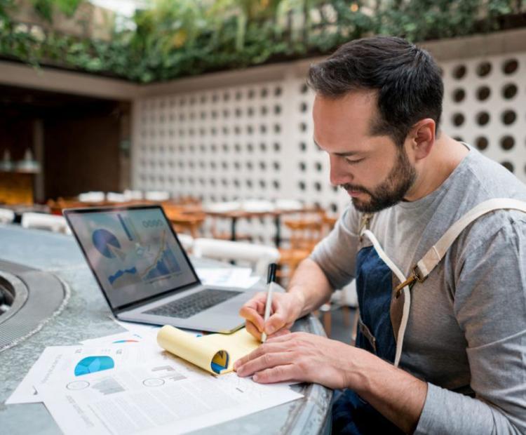A person fixing the workflows on computer and paper